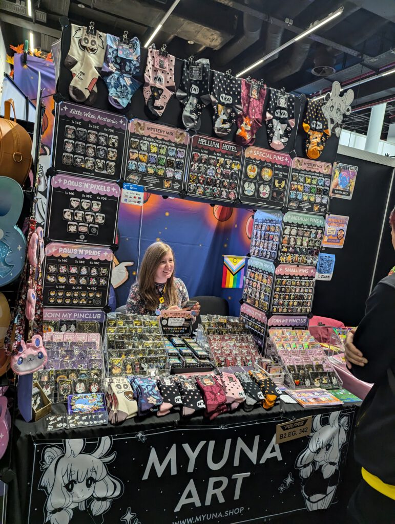 Künstlerin Myuna umgeben von ihrem Merch.